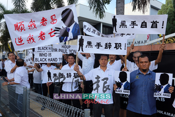 支持者举起黑手的人相剪影横幅抗议。