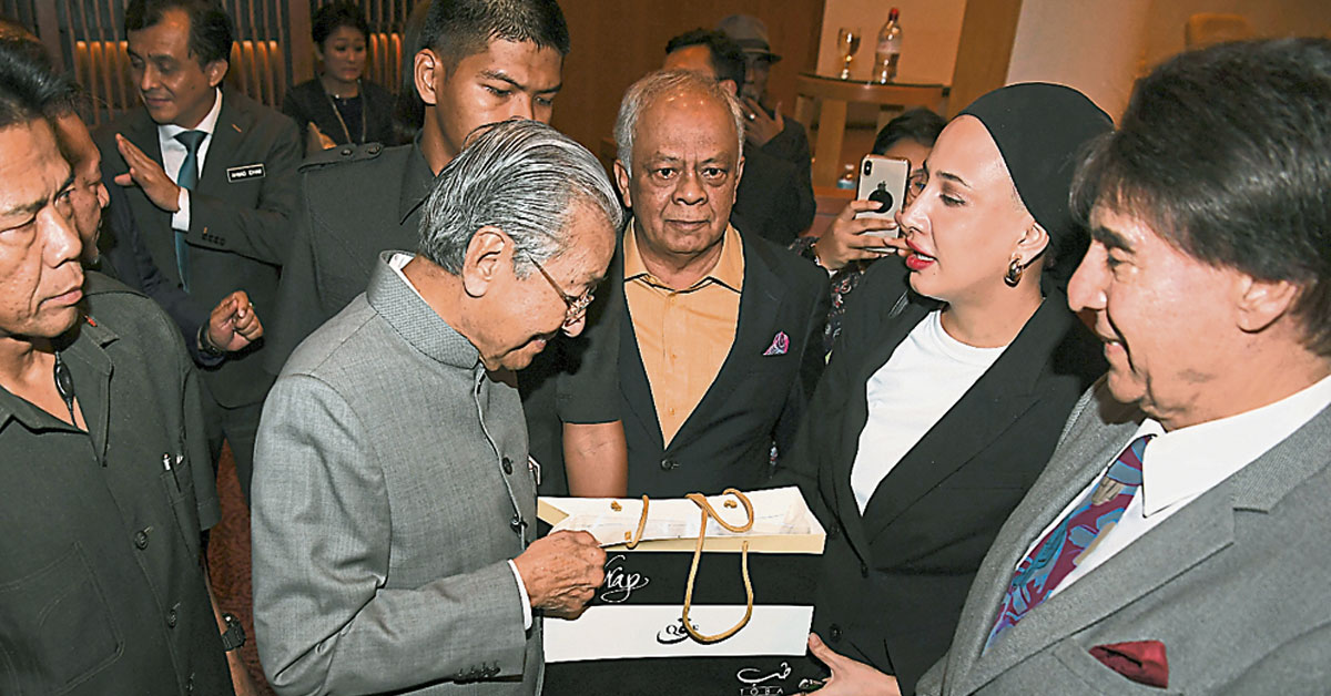 马哈迪（左2）与音乐艺术工作者交流后，收下出席者赠送的纪念品。（马新社）