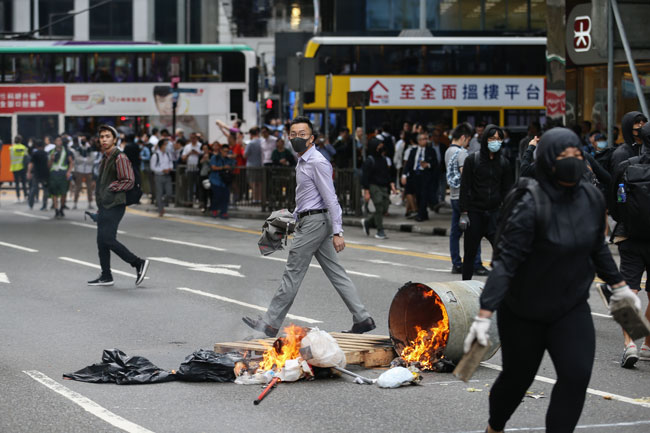 一名身穿办公室衣服、戴口罩的男子，在中环参与示威。