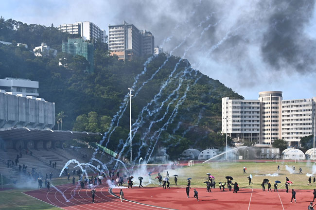 防暴警察在中文大学草场施放多枚催泪弹。（法新社）