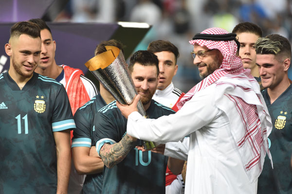 梅西率队捧起为这场友谊赛胜利者特设的奖杯。（法新社）