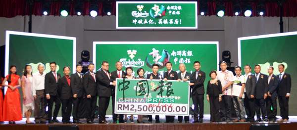 苏嘉浩（左12）在叶绍利（左8起）、何添胜、刘玉梅、黄佩诗、李才龙（右8起）和倪可东等人的见证下，移交该250万令吉模拟支票给颜登逸（右10）。