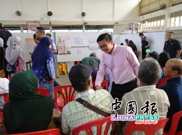 杨敦祥（右）巡视各投票站，了解投票情况。