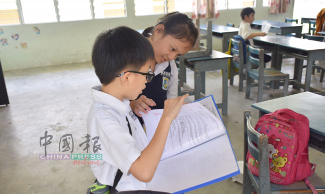 两名学生们在阅读学业评估报告。