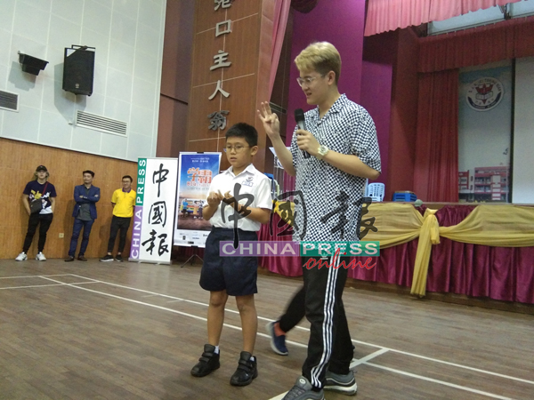 演员Clarence黄晨佑（右）和小同学互动玩游戏。