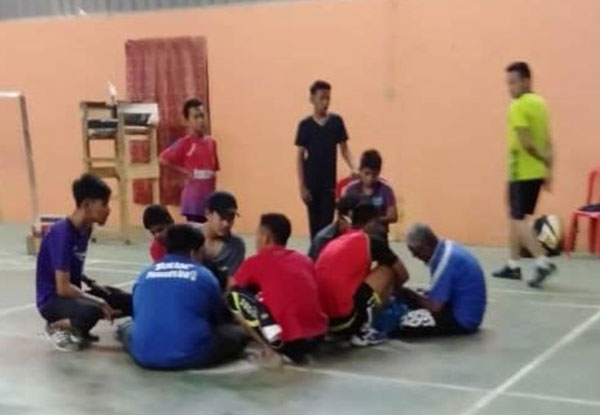 马兹兰莫哈末跌坐在地后，球友们上前查看并让他平躺。