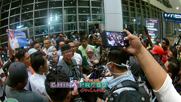 查卡利亚（左4）由国外返回机场后，受到支持者和媒体包围。