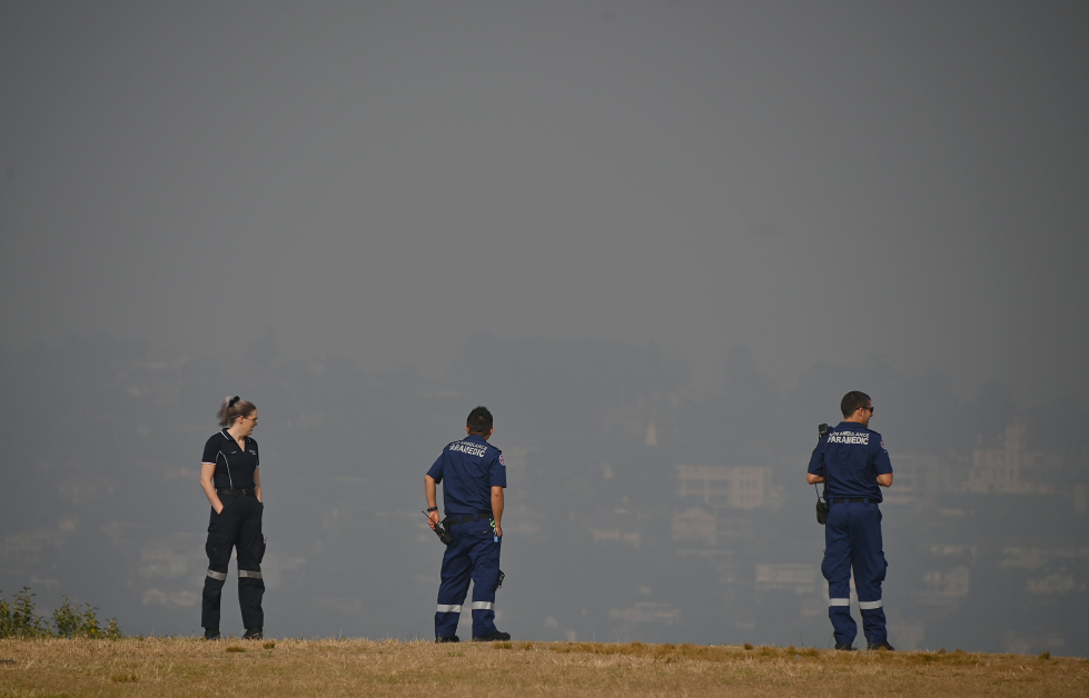 悉尼医护人员在林火烟霾中暂时休息。（法新社）