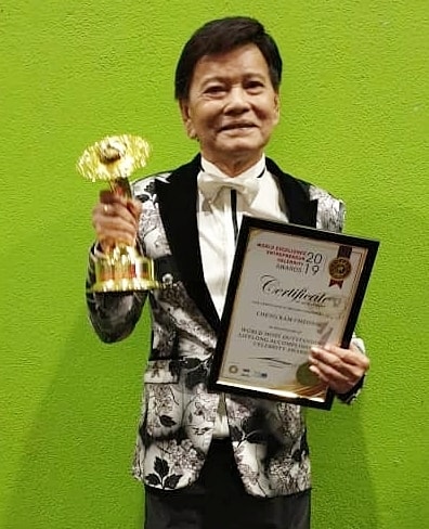 郑锦昌生前拿着奖杯和奖状开心的与大家分享他的喜悦！