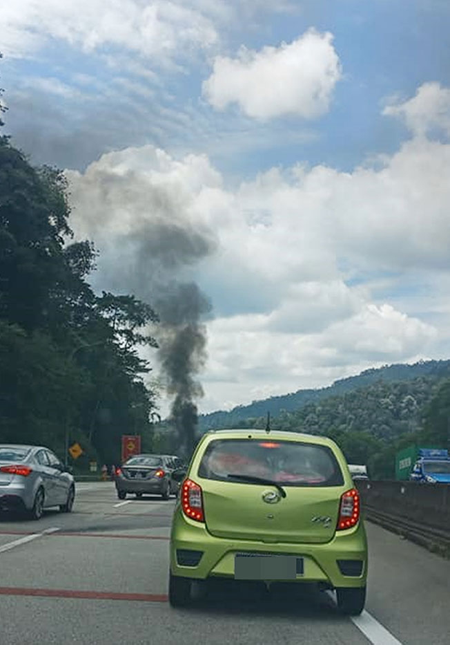 轿车着火，远处看到浓烟。（图由凌美翠提供）