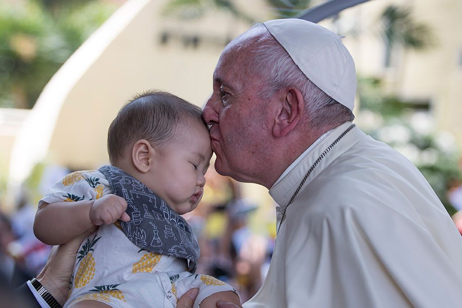 方济各在访问曼谷的圣路易斯医院时，向一名婴儿的额头亲吻给予祝福。（欧新社）