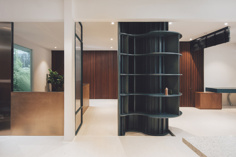 独立办公空间使用半透明屏风相隔，进一步开放了空间。充满曲线美的黑色钢框储物架，设计独特且细节精致，不规则的流线设计储物架，为平实的空间增添了灵动生气。