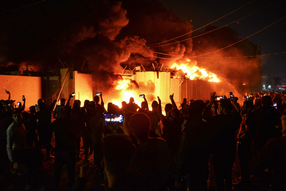示威群众看着伊朗领事馆被火烧，边欢呼叫好。（法新社）