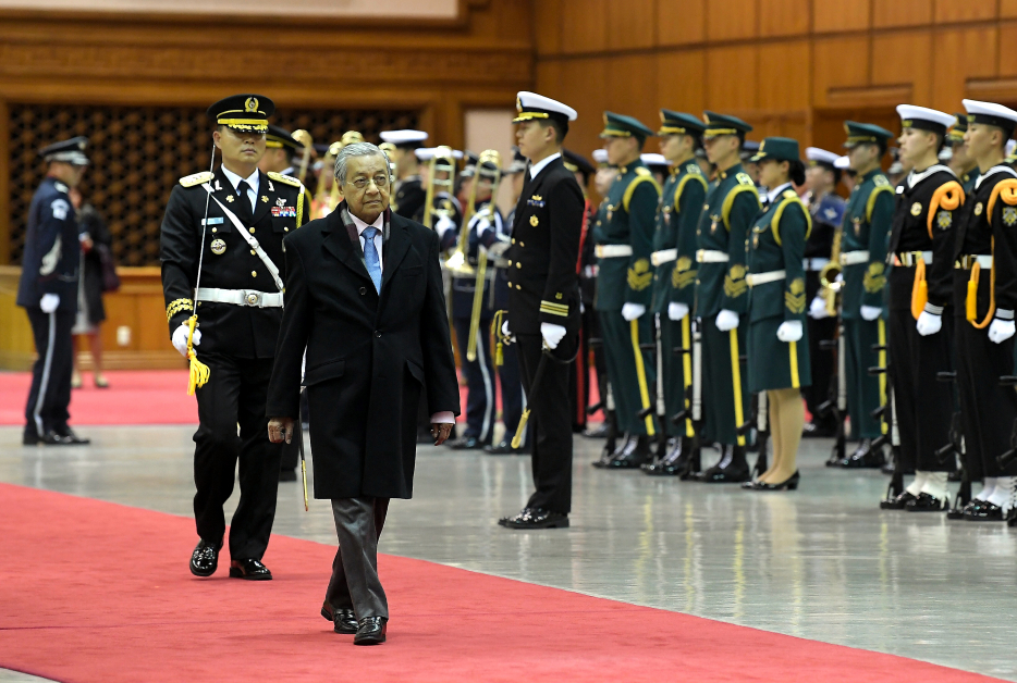 马哈迪在奏起我国及韩国的国歌后，检阅仪仗队。(马新社)