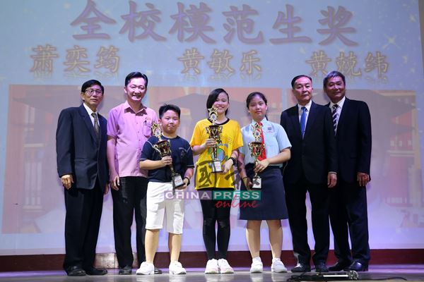 谢琪清（左2）颁发模范生奖予三名学生，左为刘双赈，右起余养金及黄国强。