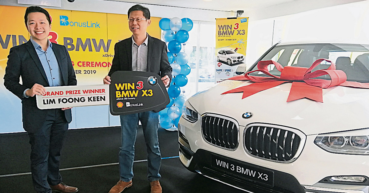 黄宏玮（左）移交模拟钥匙予“WIN 3 BMW X3”有奖竞赛第二回合大奖得主林鸿庆。