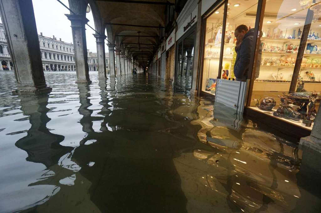 威尼斯一名店主无奈地望着商店前面的积水。