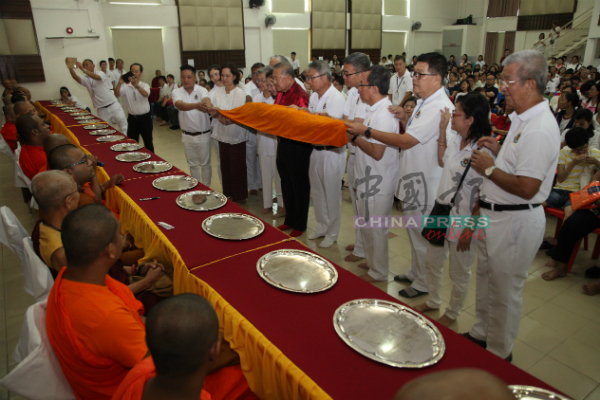 苏宝胜（红衣者）率领理事部成员为僧团献上自制袈裟。
