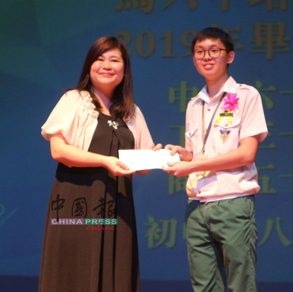 其中一班毕业生代表赠送礼物给母校，由黄雪莱（左）接领。