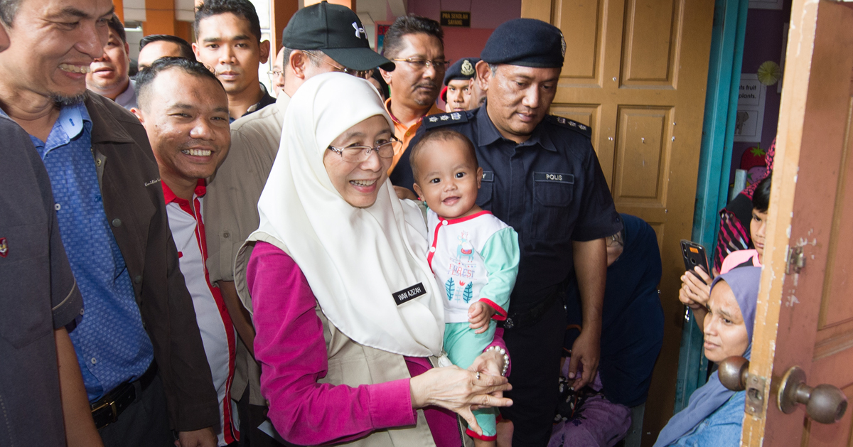 旺阿兹莎巡访兰斗班让疏散中心时，抱着灾民的孩童，展现亲切的一面。