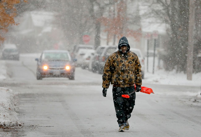 美国密苏里州街道大雪纷飞，路人在雪中漫步。（美联社）