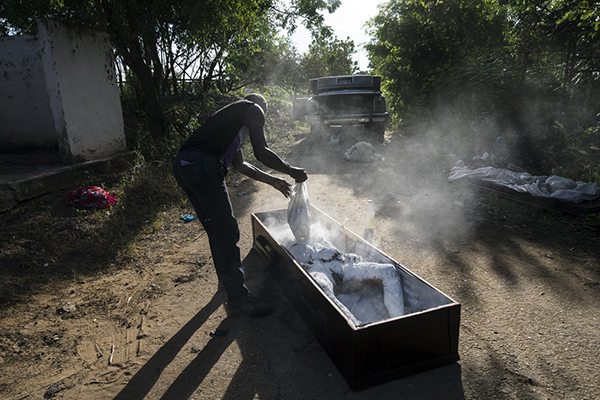 一名公墓工人正对贾西亚的遗体进行防腐处理。（美联社）