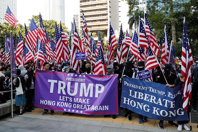 参与“感谢美国保护香港大游行”的香港民众，手举美国国旗和标语牌，呼吁“特朗普总统让香港再次伟大”。（美联社）