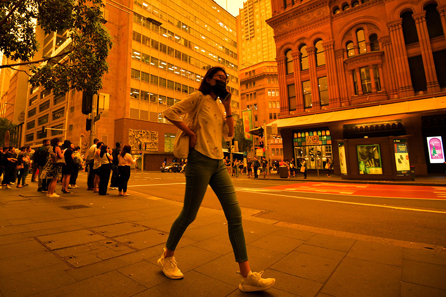 悉尼一名女子周五戴着口罩出街。（欧新社）