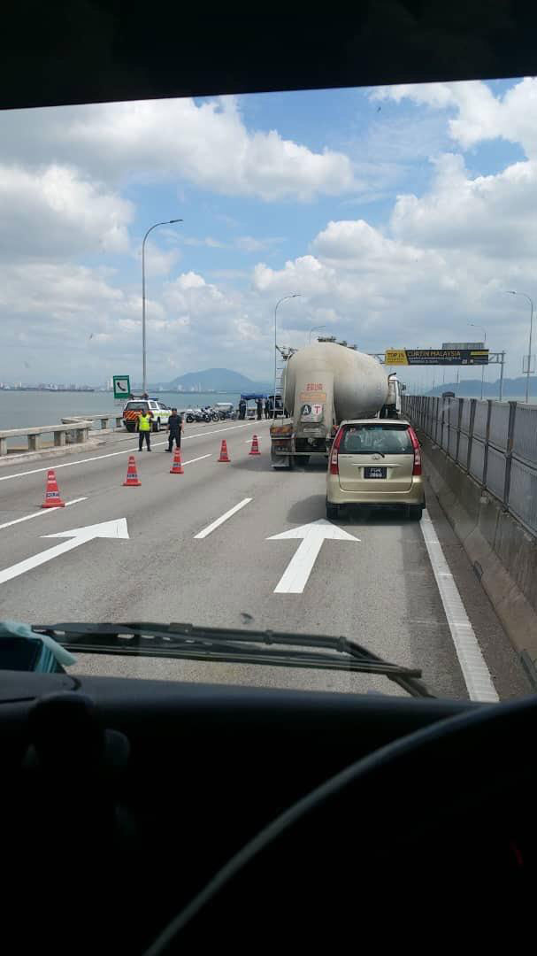 警员在大桥上设立路障，逐个检查车辆。
