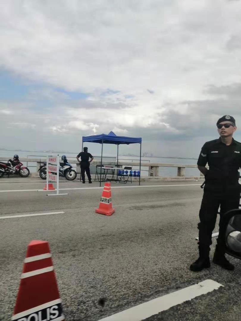 警方在大桥上设立路障，造成塞车。