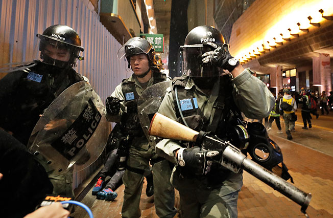 防暴警手持催泪弹枪与示威者对峙。（美联社）