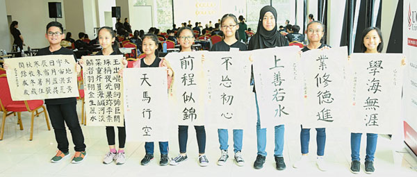 八名来自沙巴的友族中小学生，写得一手好书法，展现马来西亚跨种族的文化交融。