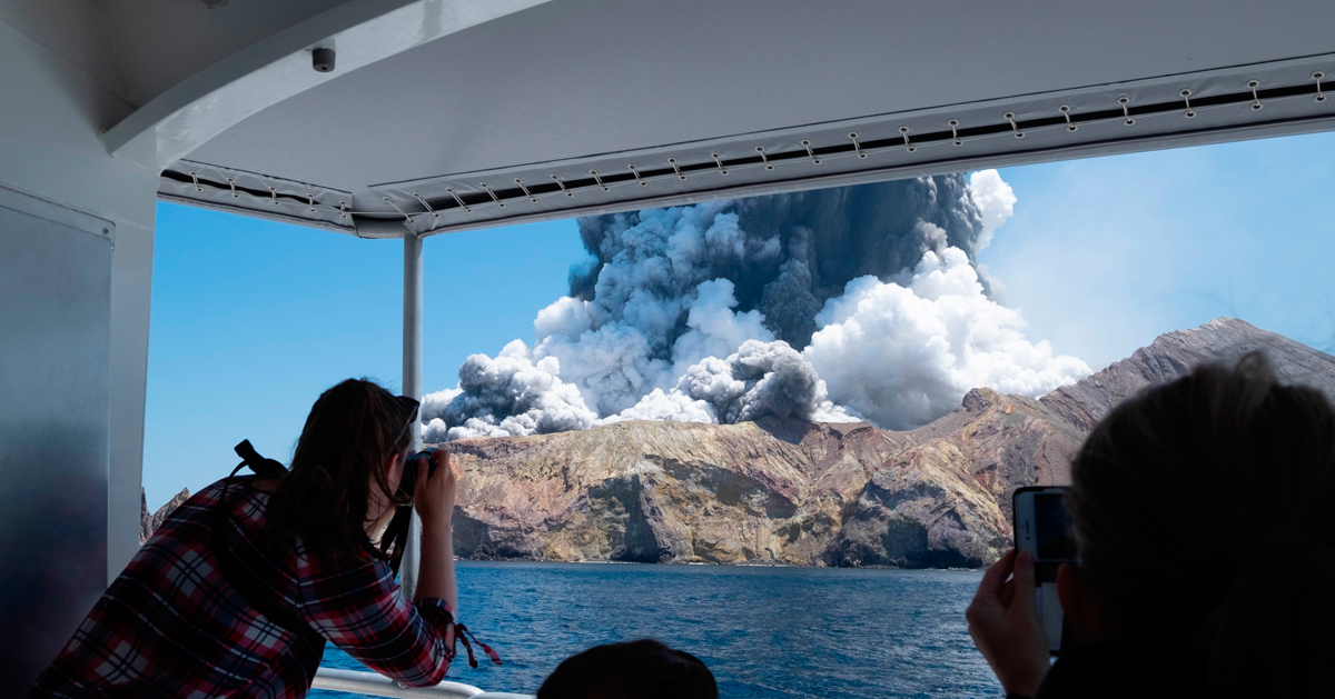 火山爆发时，游客拿起手机拍下画面。（美联社）