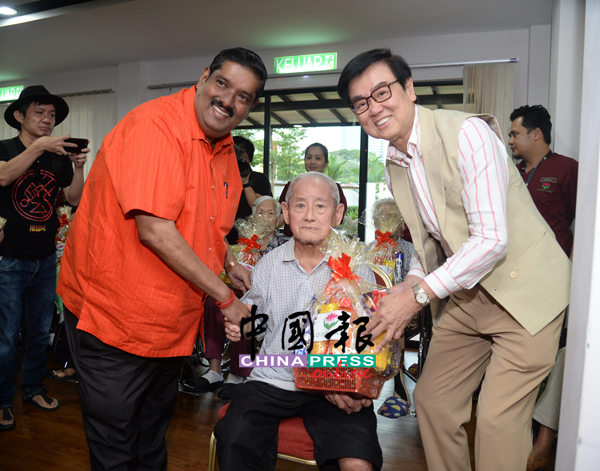 Lotus Five Star老板Datuk R. Doraisingam（左）与黄百鸣送上圣诞礼篮给长者。