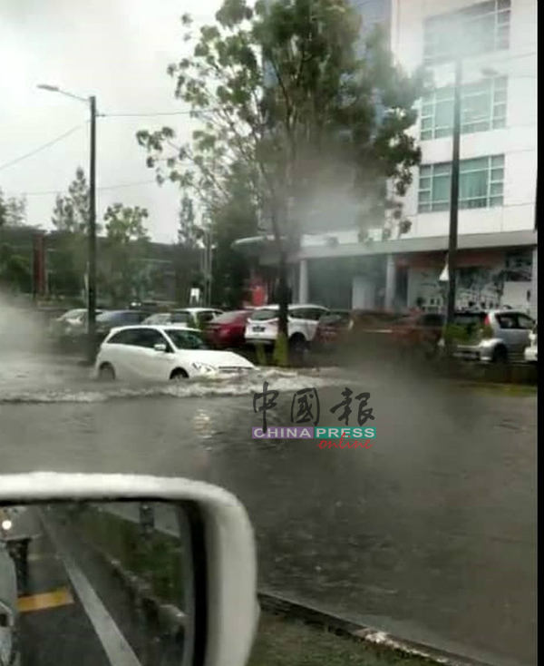 突发水灾导致道路积水，车辆涉水而过，经常有车辆因此抛锚。（档案照）