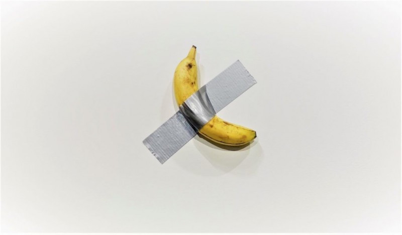 意大利艺术家卡特兰用防水胶带把香蕉贴到墙上，完成这套名叫“丑角”（Comedian）的艺术品。（互联网）