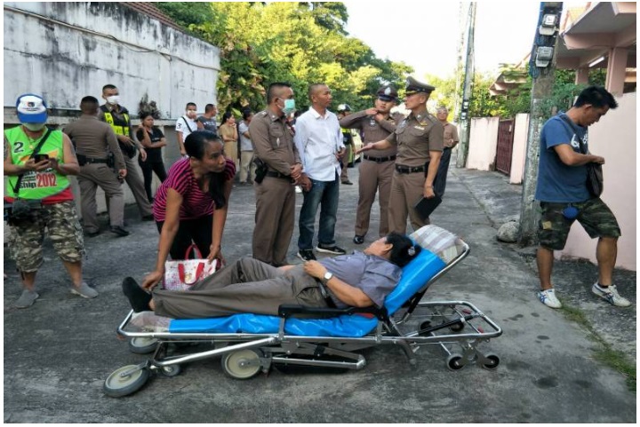 暖拉沃躺在病架上，被送上救护车。