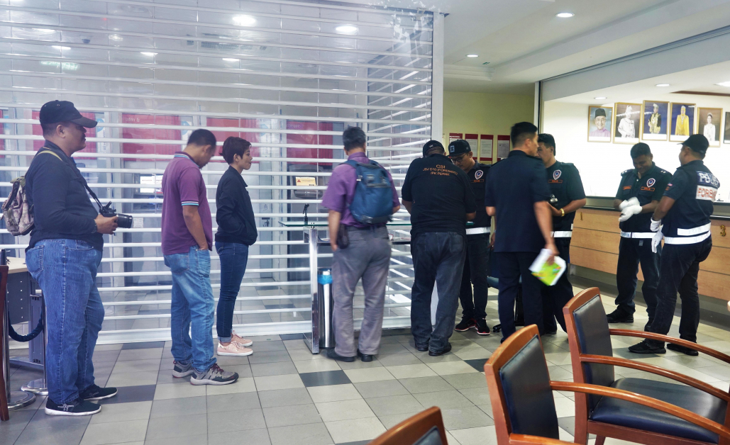 大批警察在被抢劫的银行内，展开调查工作。