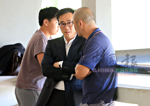 女嫌犯丈夫（右）与代表律师马国良讨论案情。
