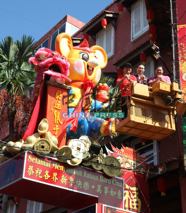 颜天禄（右起）、郑伟松及李传财，为“好运鼠”吉祥物挂上红绫。