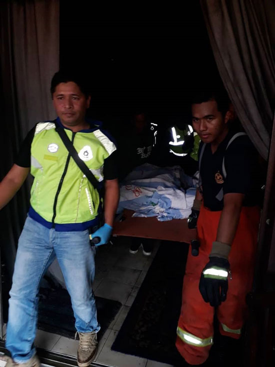 警方与消拯员全力将死者遗体抬出，准备送往麻坡医院太平间。