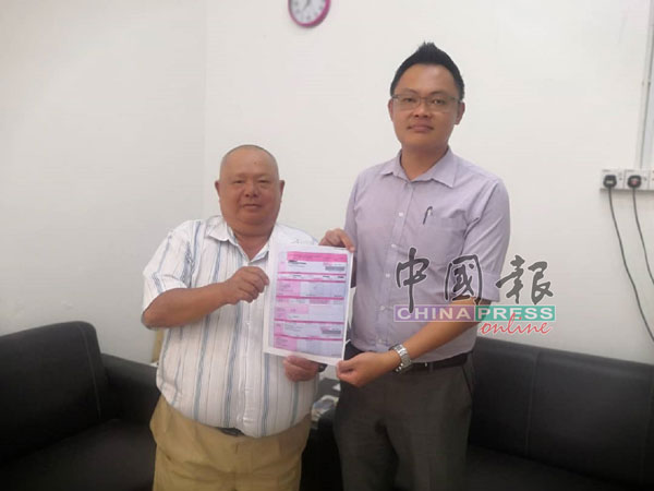 美律区州议员特别助理谭大新（左起）及新村发展官薛智祥，展示商家和居民针对地税暴涨的投诉。