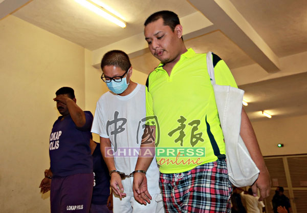 被告陈健业（右2）涉嫌谋杀双亲，被庭警带往法庭。