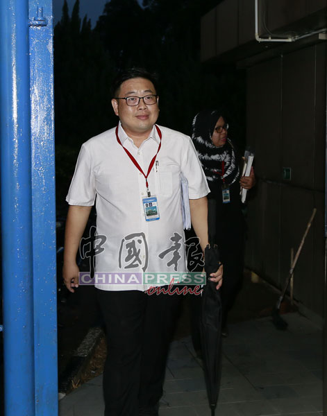 吴健南（前）在律师诺法拉依扎的陪同下，步出警局。