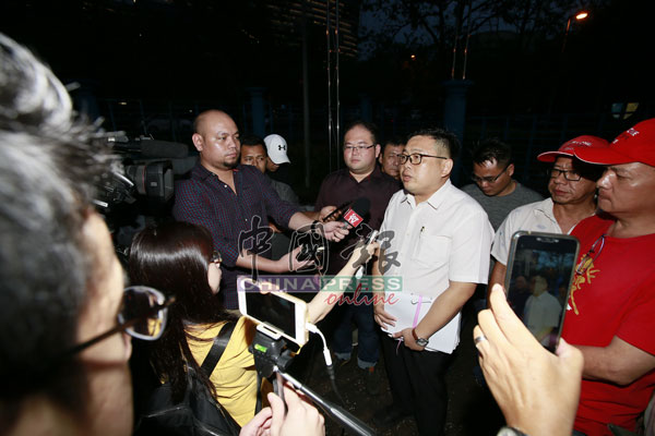吴健南（右4）接受媒体采访。