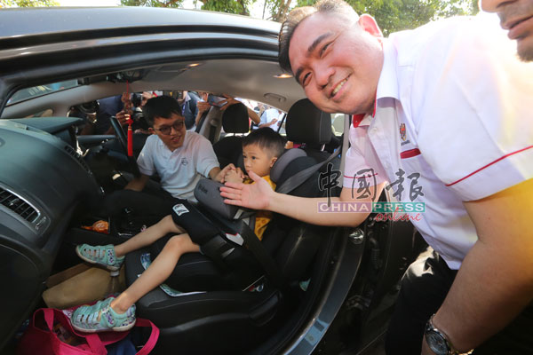 陆兆福（右）检查进入休息站的车辆，确保他们有为孩子安装儿童安全座椅。