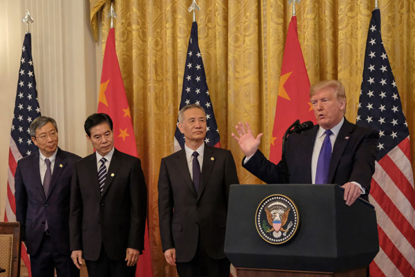 特朗普（右）在签字前发表冗长谈话，中国国务院副总理刘鹤（左3）率领的中方代表团在旁枯等。（欧新社）