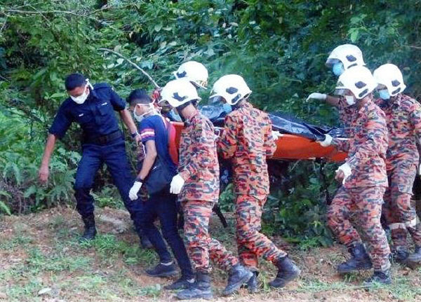警员及消拯员把死者的遗体从丛林处抬出，送往医院太平间。