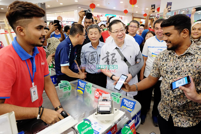 林冠英（右2）到峇眼亚占特易购，巡视使用电子红包的情况。