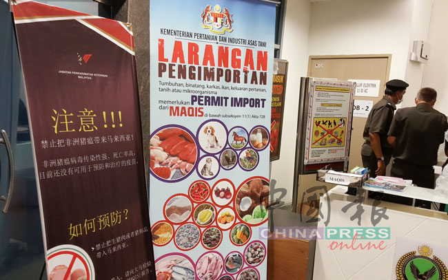 槟城国际机场入境厅的MAQIS部门，展示“非洲猪瘟须知”及被禁止携带入境的食品海报。